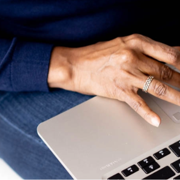 Photo of two hands typing on a Macbook laptop